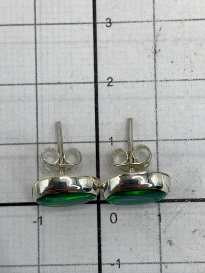 Aretes sobre paño neutro junto a regla de medida mostrando 1.3 cm