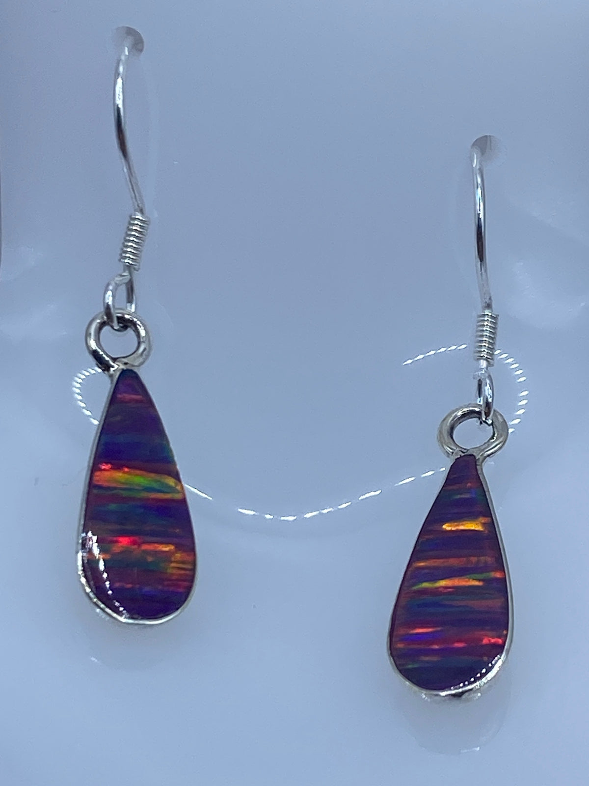 Par de aretes de plata 925 con ópalo de fuego morado, mostrando reflejos dorados y rojos