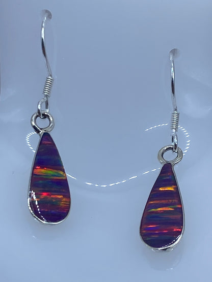 Par de aretes de plata 925 con ópalo de fuego morado, mostrando reflejos dorados y rojos