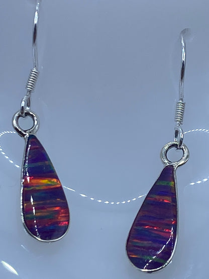 Detalle del engaste de plata y la gota de ópalo con bandas de color morada y naranja