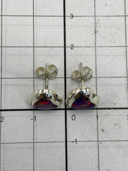 Aretes de ópalo fuego sobre fondo blanco junto a medida de escala