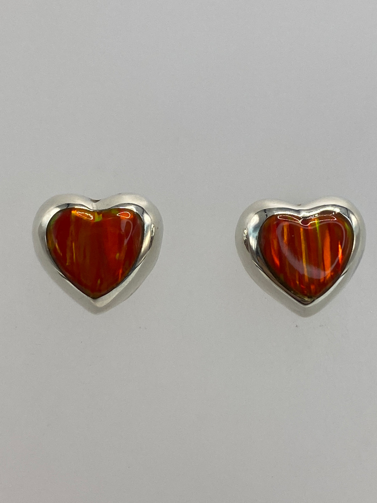 Aretes sobre patrón de medida mostrando el largo de 1.4 cm