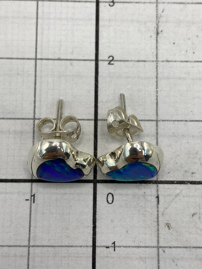 Aretes de ópalo de fuego sobre medidor de tamaño, mostrando el largo de 1.3 cm