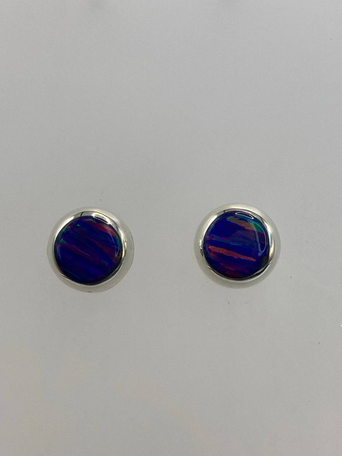 Par de aretes de plata 925 con ópalo de fuego morada, 1.3 cm, sobre fondo blanco