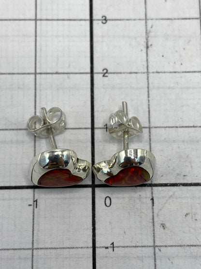 Aretes sobre regla de centímetros mostrando tamaño real de 1.3 cm
