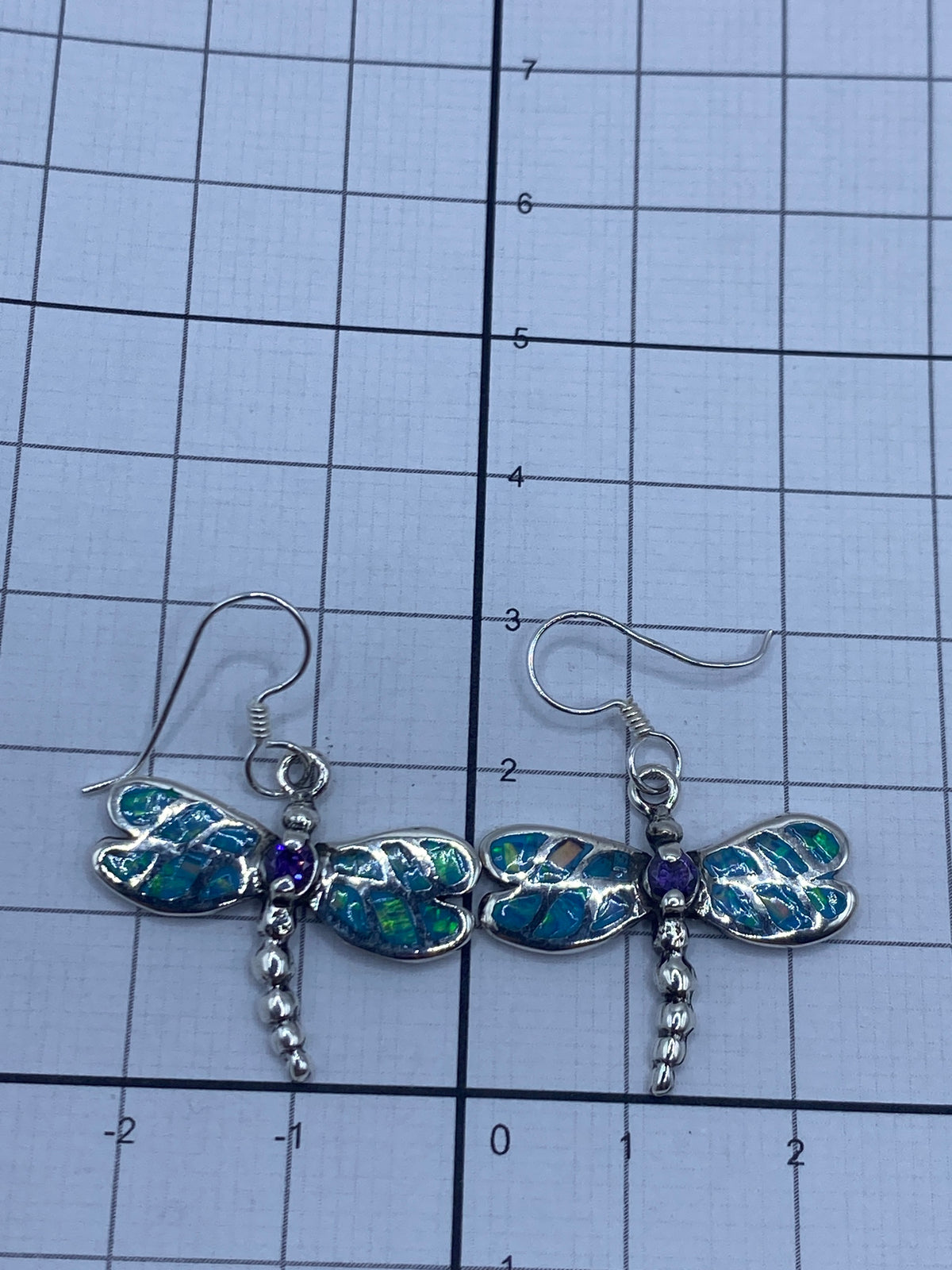 Aretes en par sobre fondo blanco con gancho de plata visible