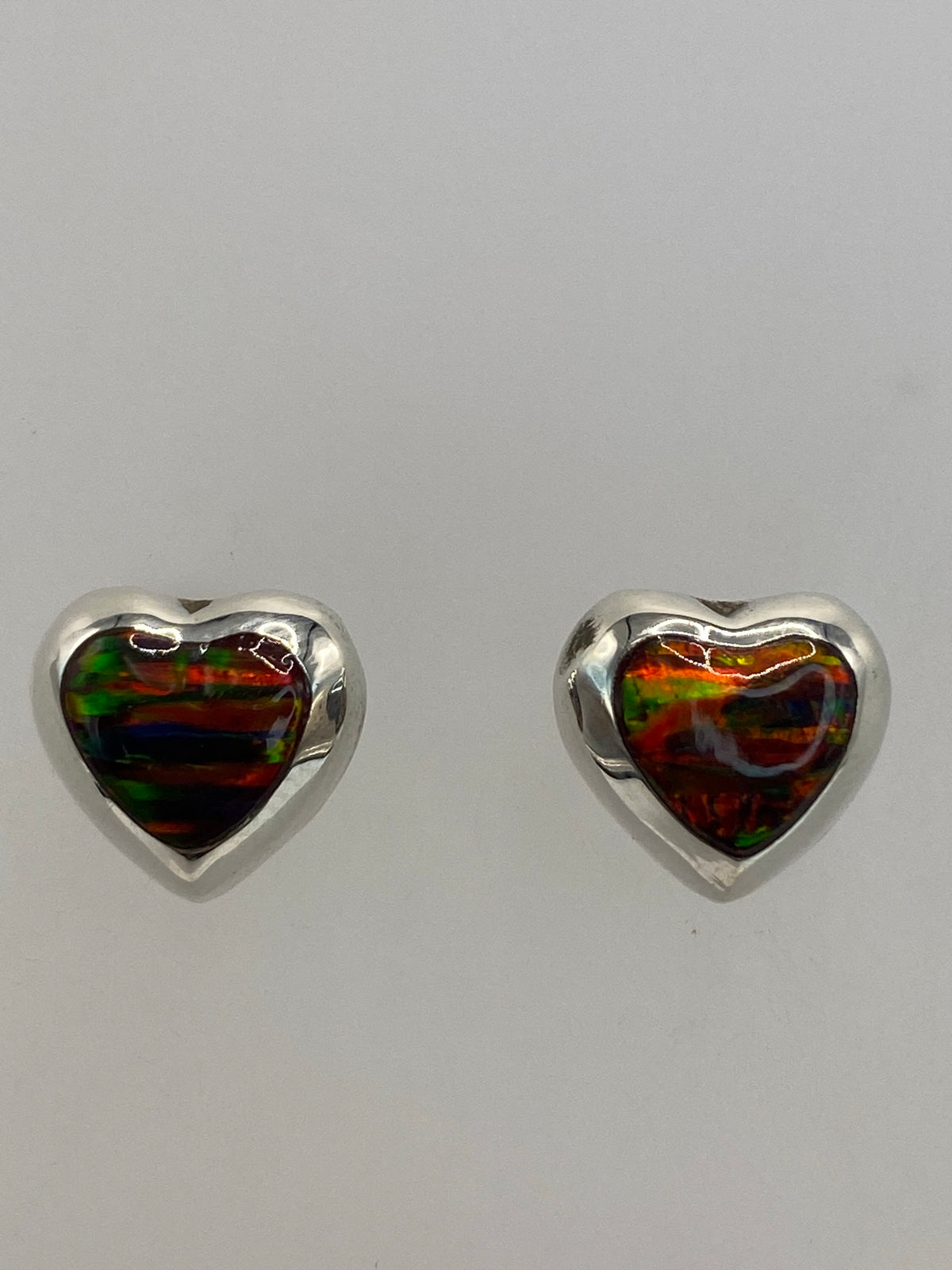 Aretes sobre regla métrica mostrando largo de 1.4 cm, vista frontal