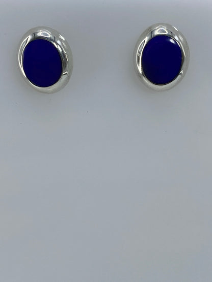 Par de aretes de plata 925 con piedra azul engastada, sobre fondo blanco