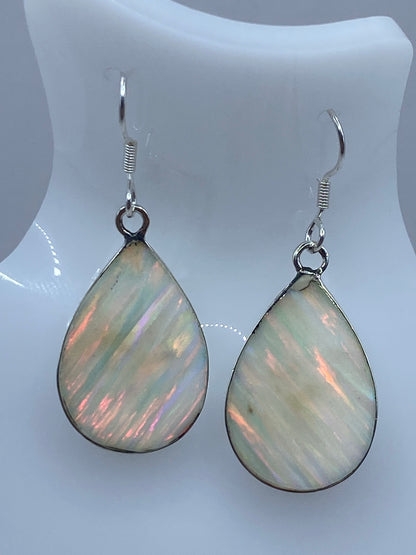 Par de aretes de plata con Ópalo de Fuego en forma de gota, mostrando destellos rojos y verdes