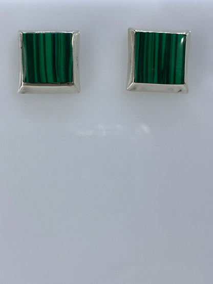Detalle frontal de arete cuadrado con incrustación multicolor, mostrando la técnica a mano