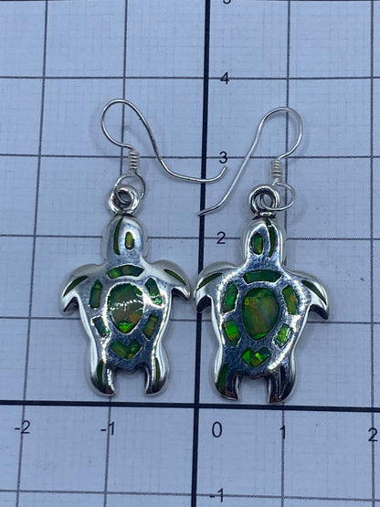 Aretes sobre fondo negro mostrando el reflejo del opalo de fuego