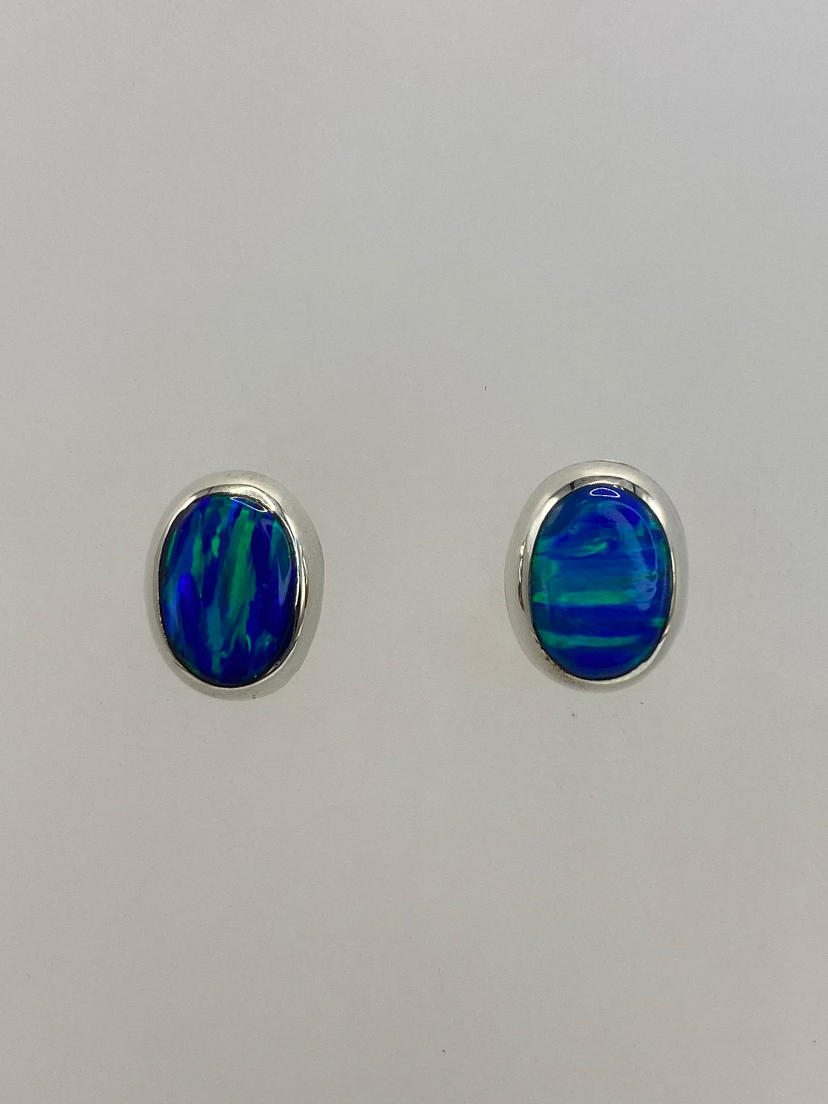Par de aretes de plata con ópalo de fuego azul engastado a mano