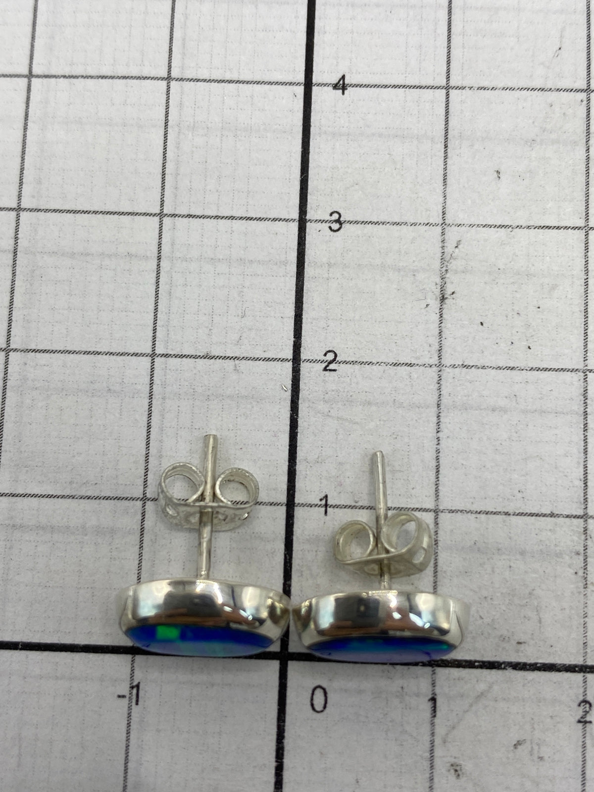 Reverso de los aretes mostrando el Quinto 925 y el cierre de seguridad