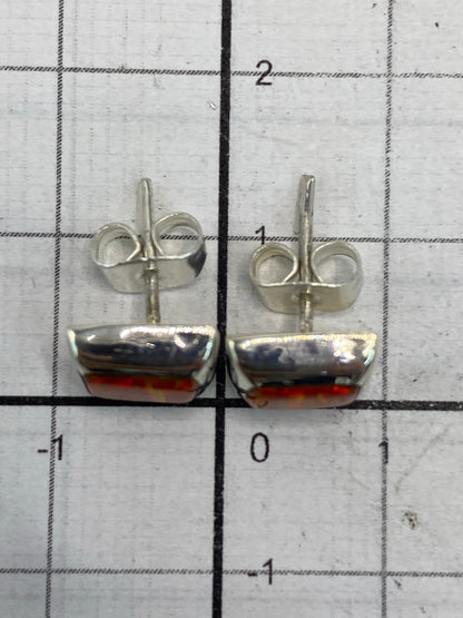 Aretes de ópalo de fuego naranja sobre fondo blanco para mostrar brillo de la piedra