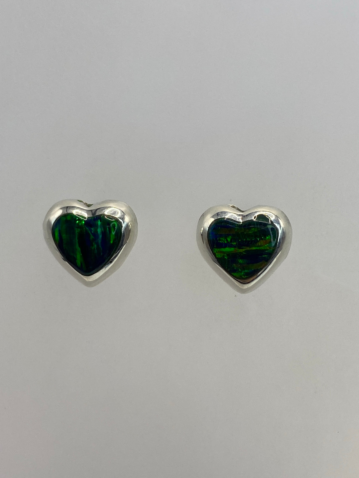 Par de aretes de plata 925 con opalo de fuego verde engastado a mano, sobre fondo blanco