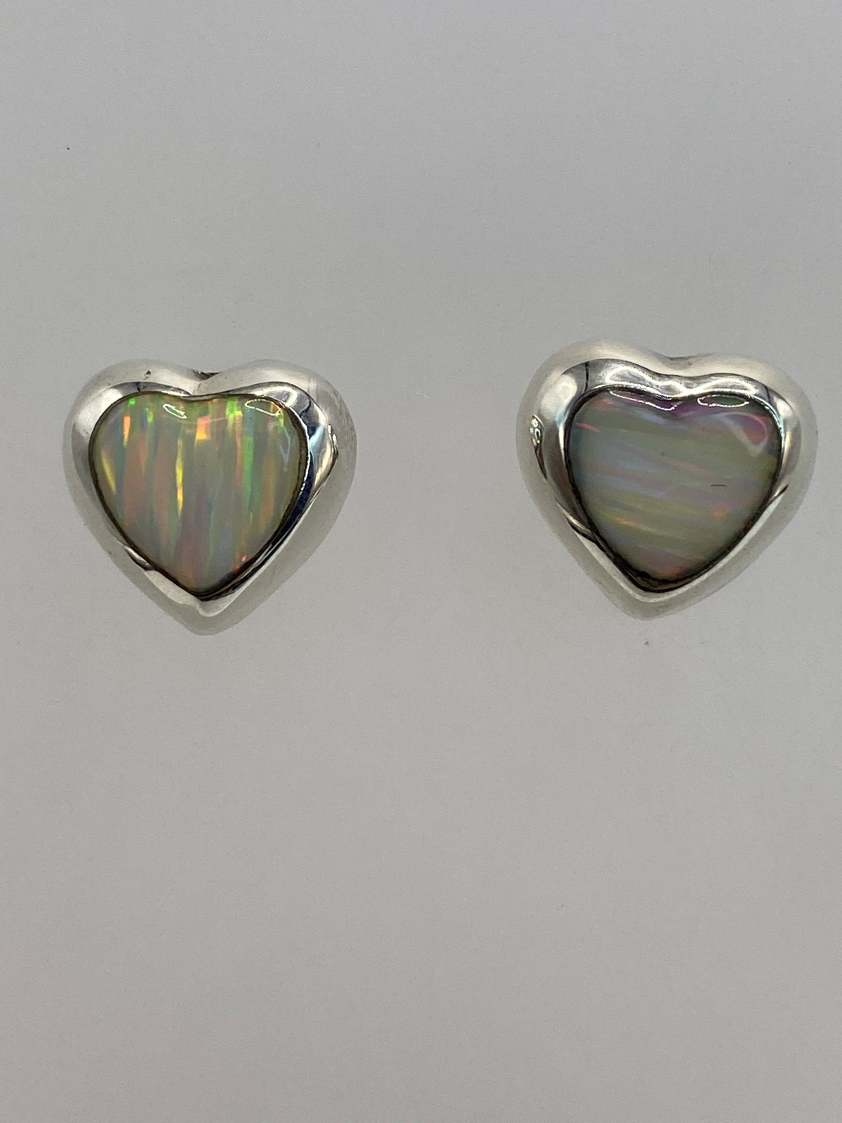 Aretes colocados sobre medidor de centímetros, tamaño 1.4 cm