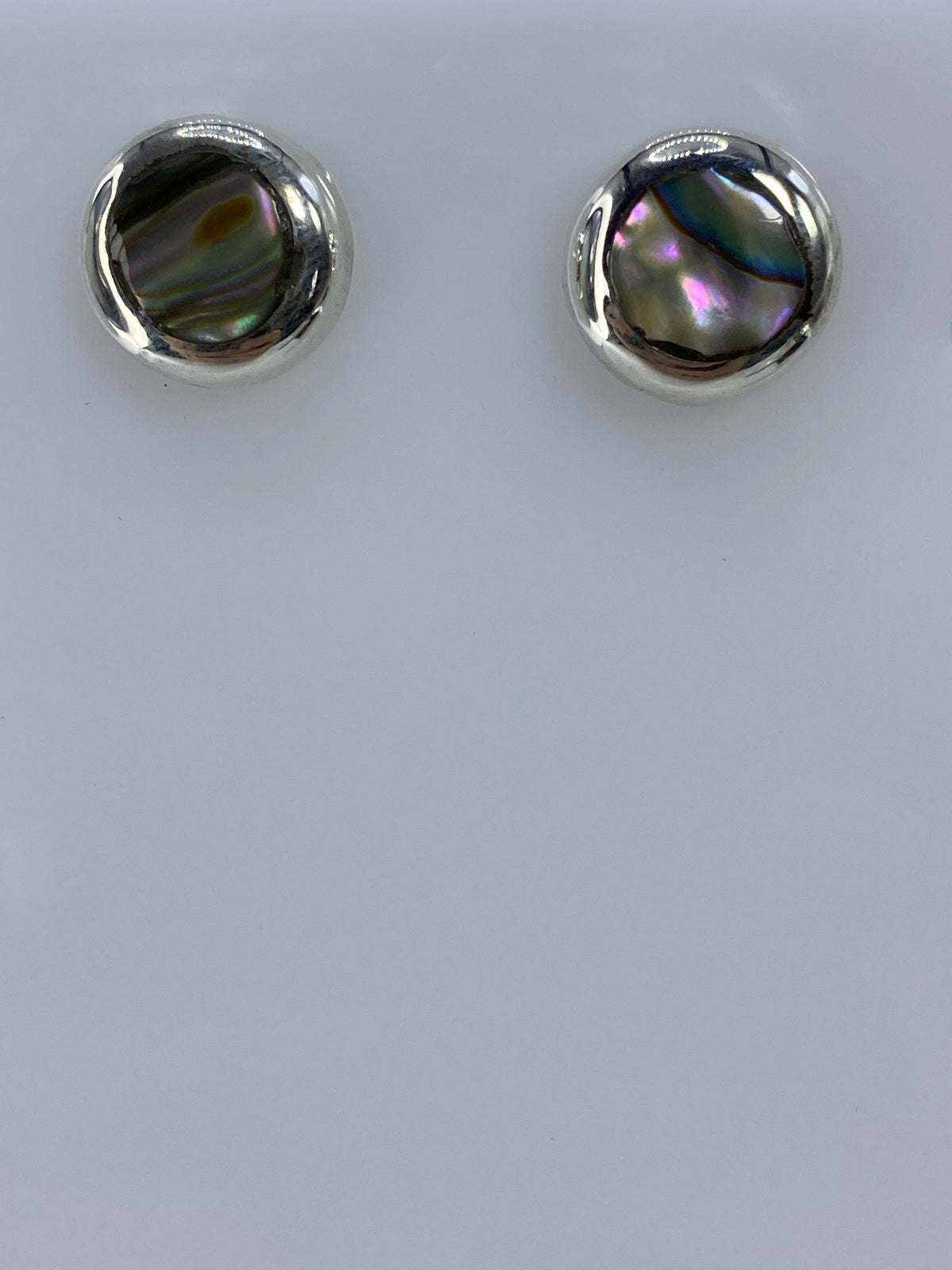 Aretes de plata 925 con piedras multicolor engastadas, vistos desde arriba en fondo claro