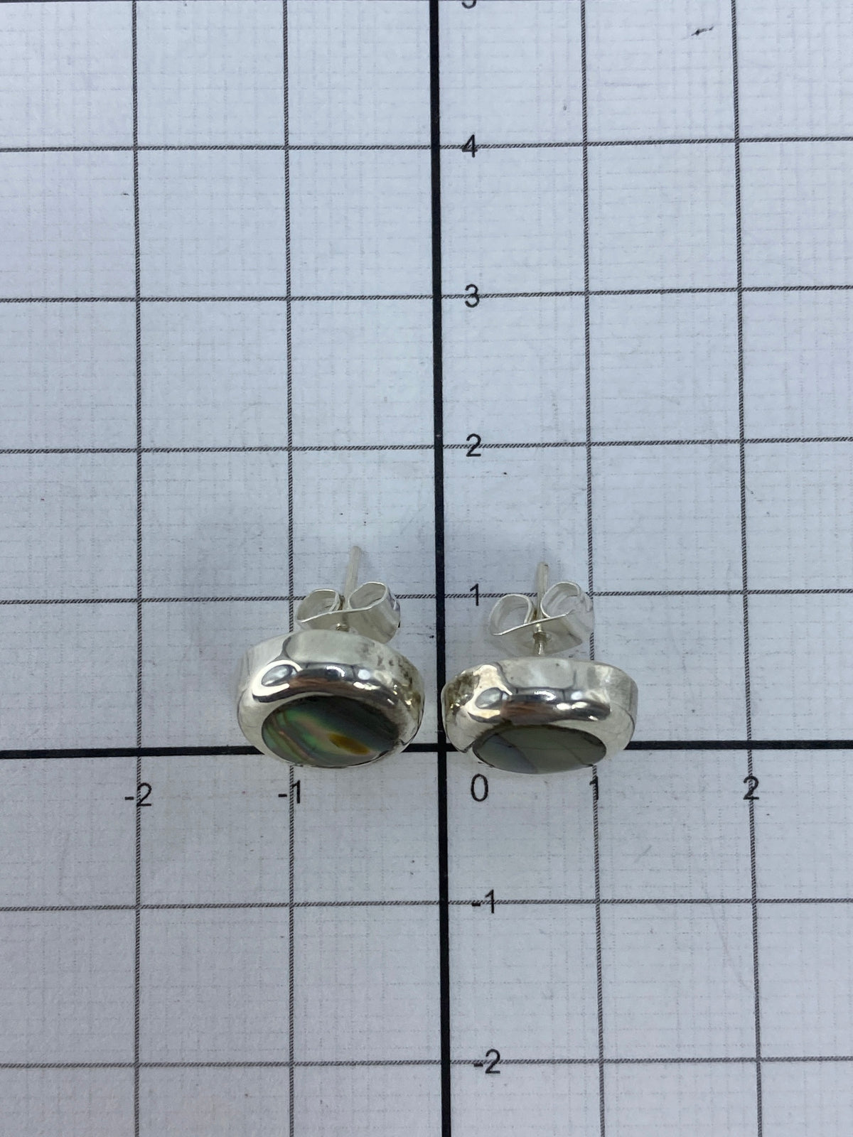 Reverso de los aretes mostrando el Quinto 925 y el poste de seguridad