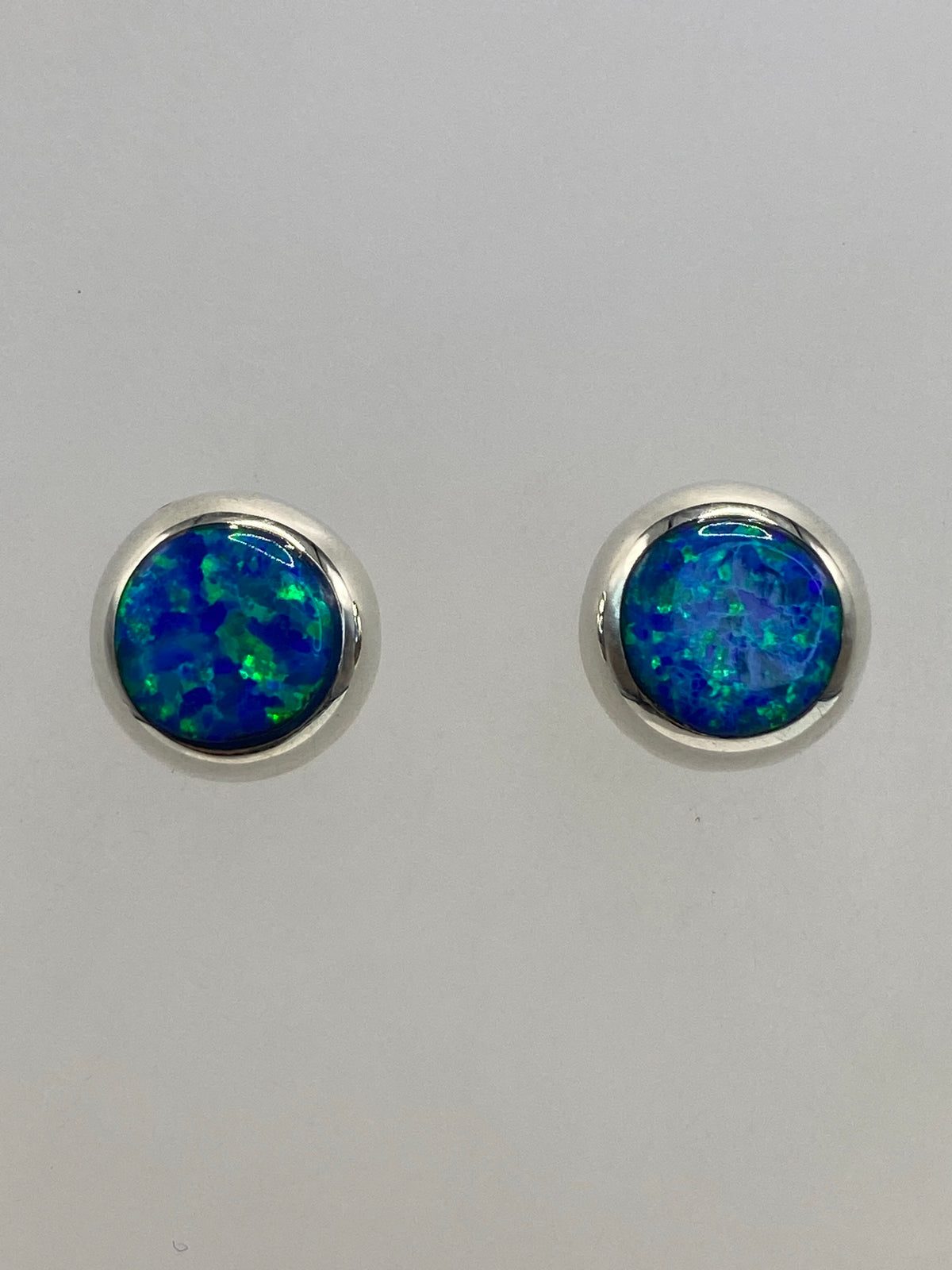 Los dos aretes lado a lado mostrando el color azul cielo uniforme