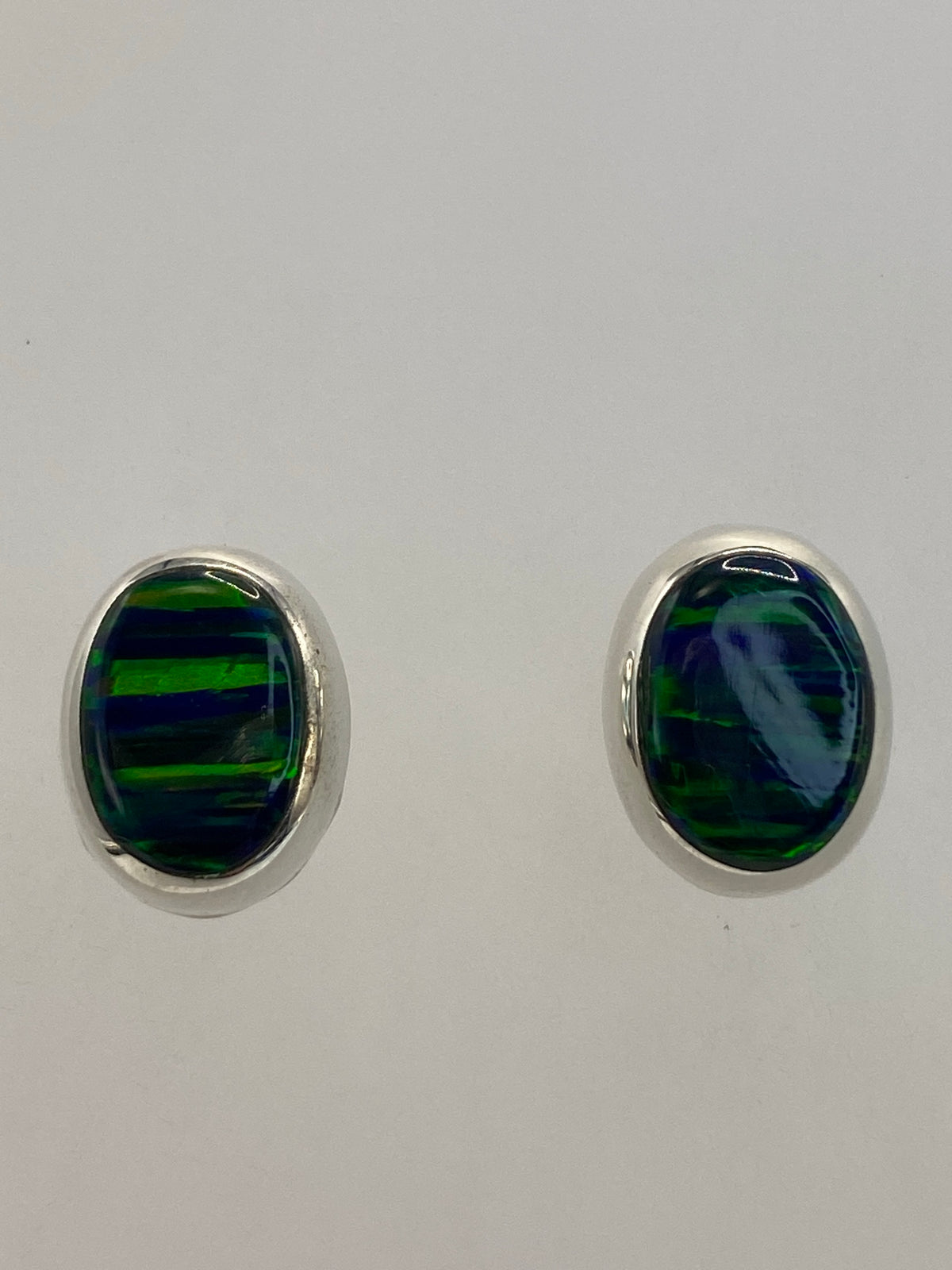 Aretes colocados en las orejas mostrando el tamaño delicado de 1.4 cm