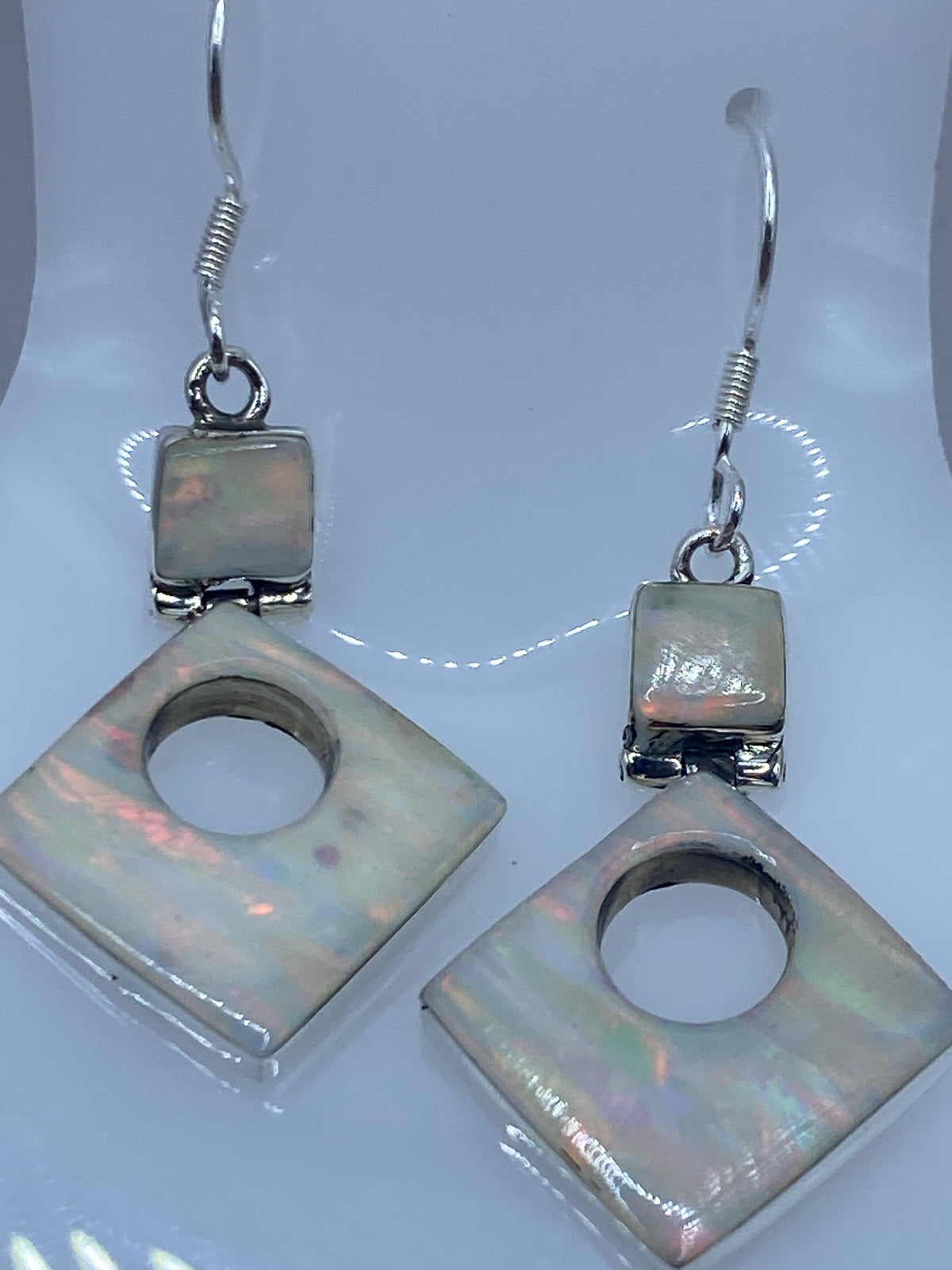 Aretes sobre escala mostrando peso de 3 gramos y marca del Quinto 950