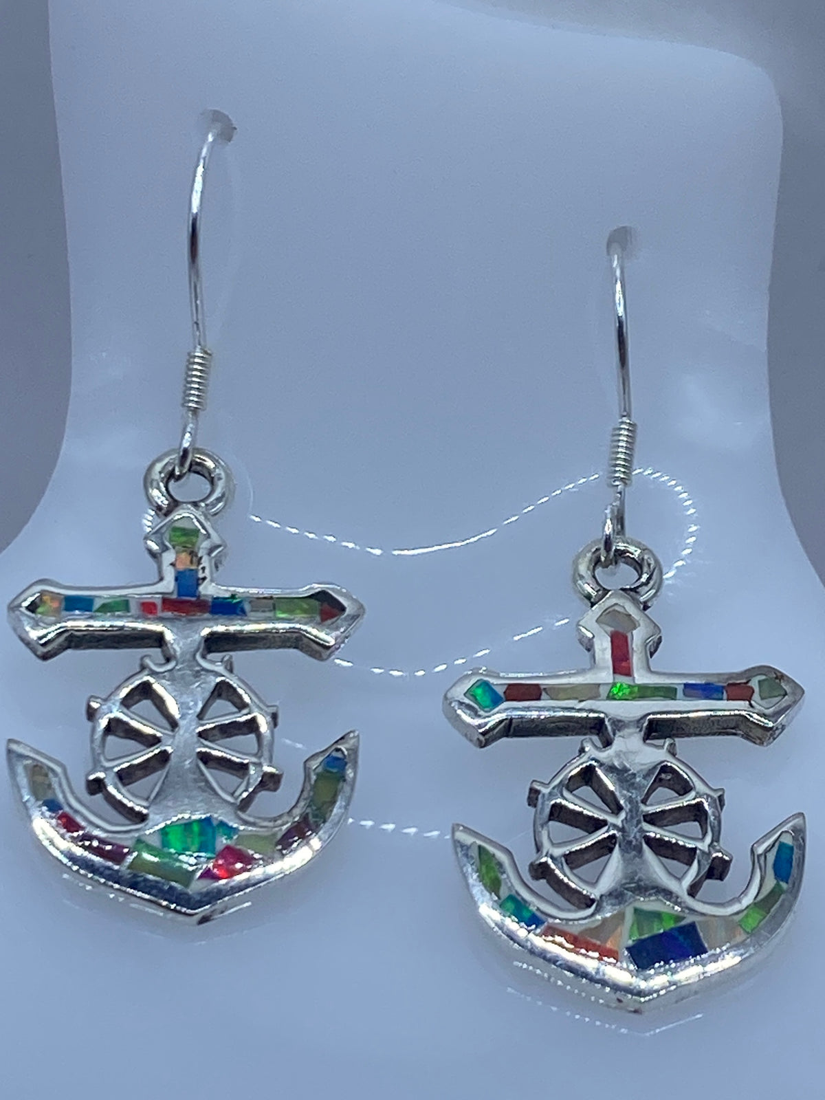 Aretes de frente mostrando la rueda de timón calada y el brillo del ópalo