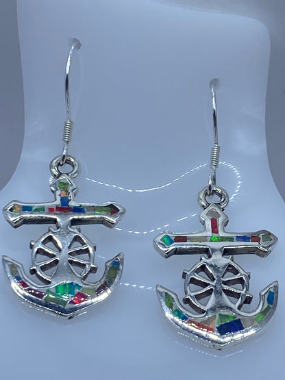 Aretes de frente mostrando la rueda de timón calada y el brillo del ópalo