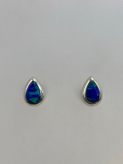 Par de aretes de plata con ópalo de fuego azul, mostrados de frente sobre fondo blanco