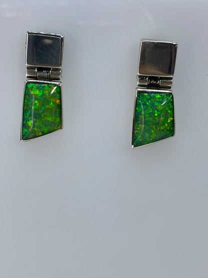Detalle frontal del ópalo de fuego verde con destellos amarillos y naranjas en cada arete