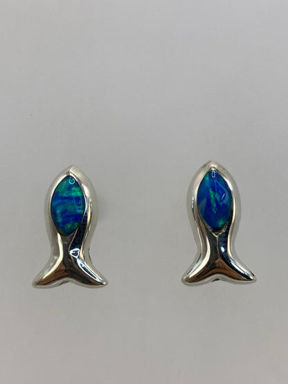 Detalle frontal de los aretes mostrando el color azul verdoso del ópalo y el brillo de la plata