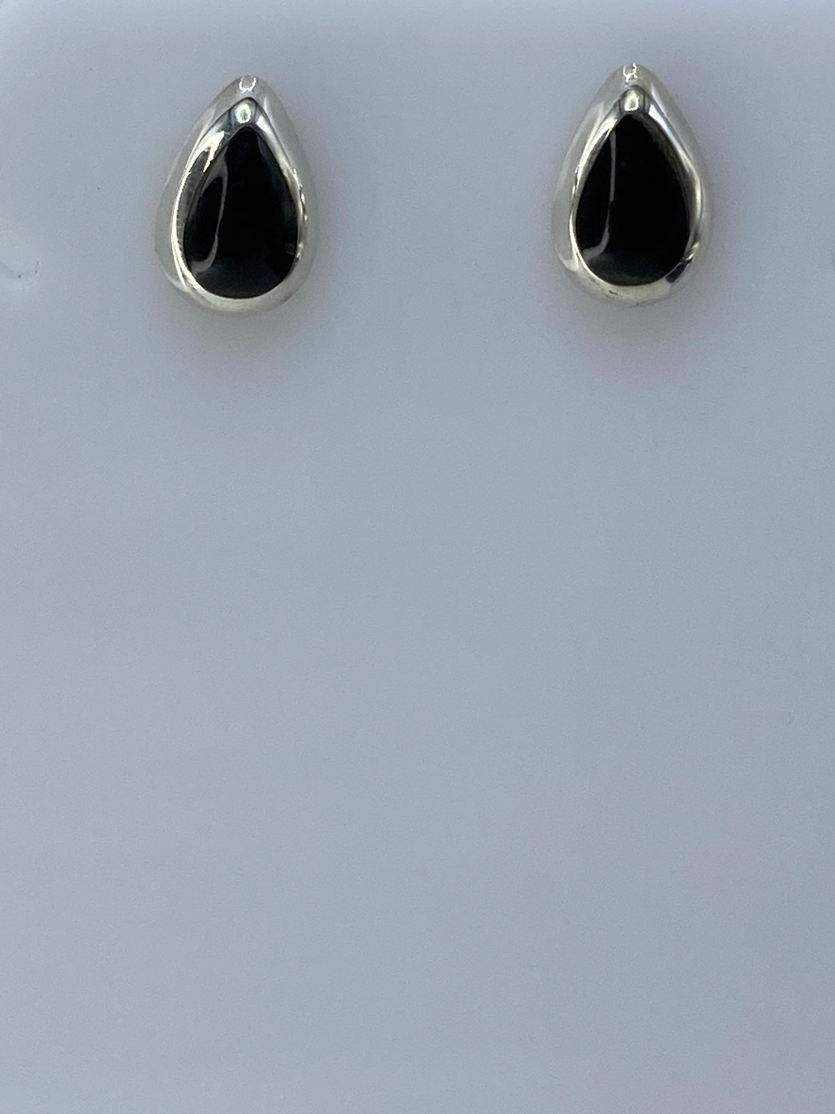 Detalle lateral de arete de plata 925 con incrustación de piedra negra