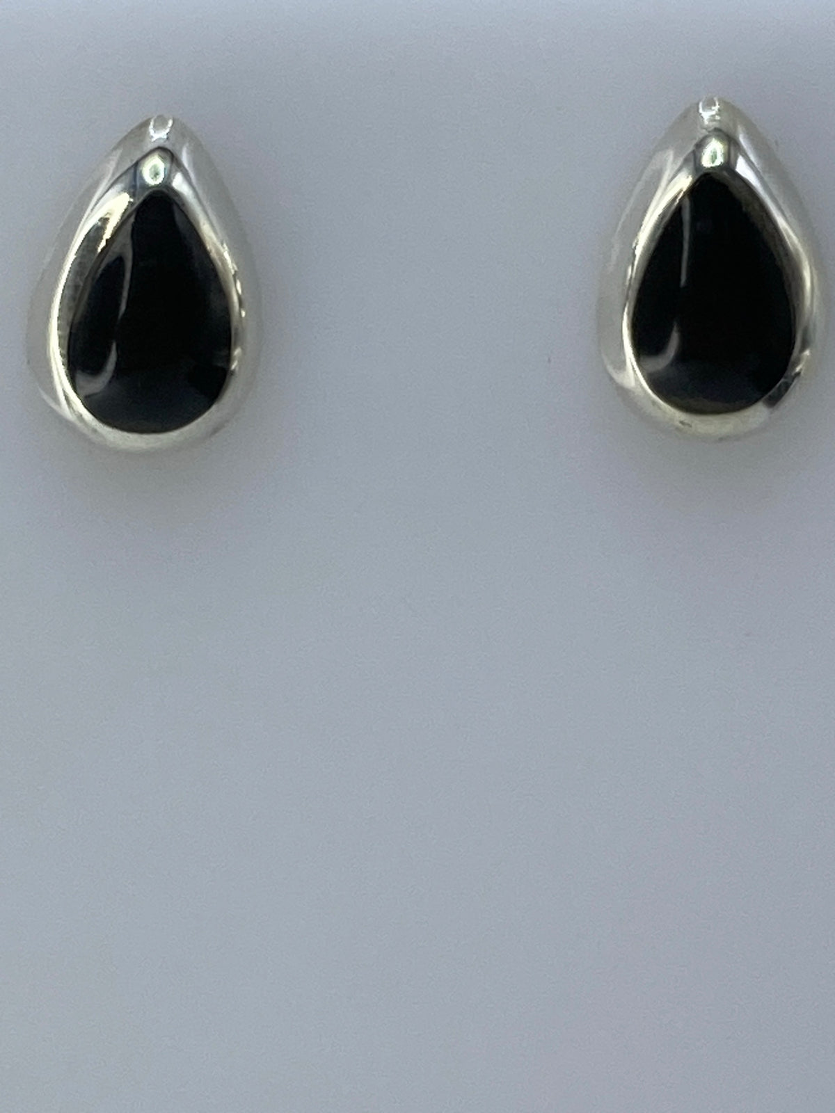 Aretes en la mano mostrando el tamaño real de 1.6 cm