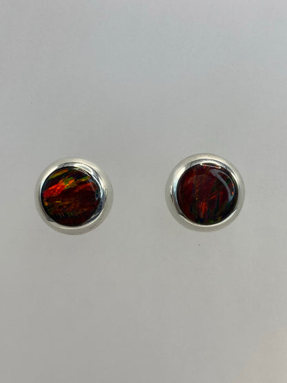 Par de aretes de plata con opalo de fuego cafe, frente a frente, mostrando el engaste redondo