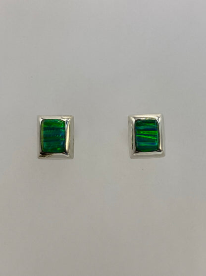 Par de aretes de plata 950 con opalo de fuego verde en fondo blanco