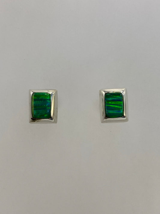 Par de aretes de plata 950 con opalo de fuego verde en fondo blanco