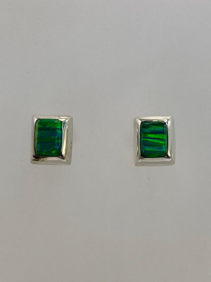 Detalle de un arete mostrando el engaste a mano de la piedra verde luminosa