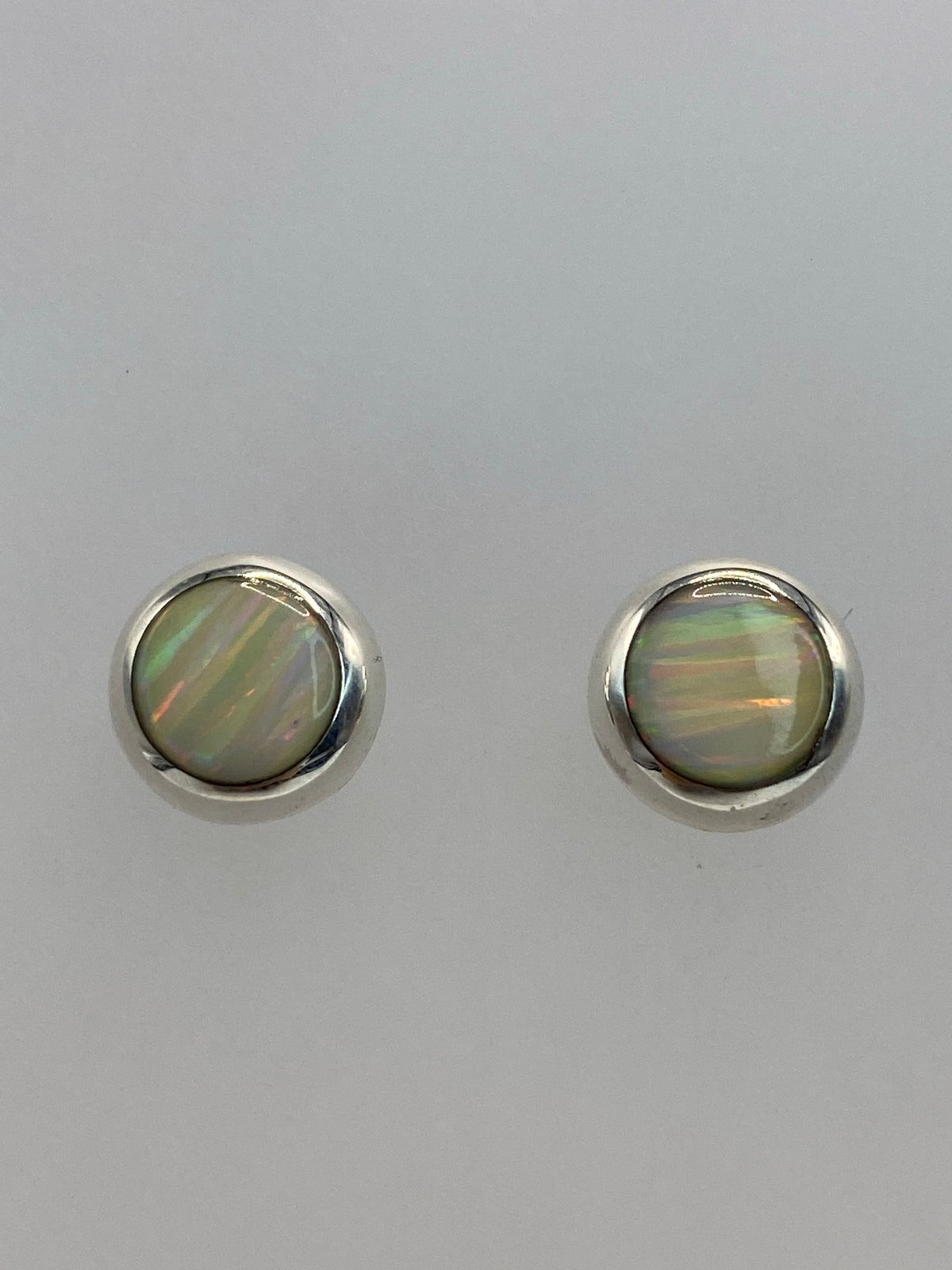Detalle del engaste a mano del ópalo en los aretes de plata 925