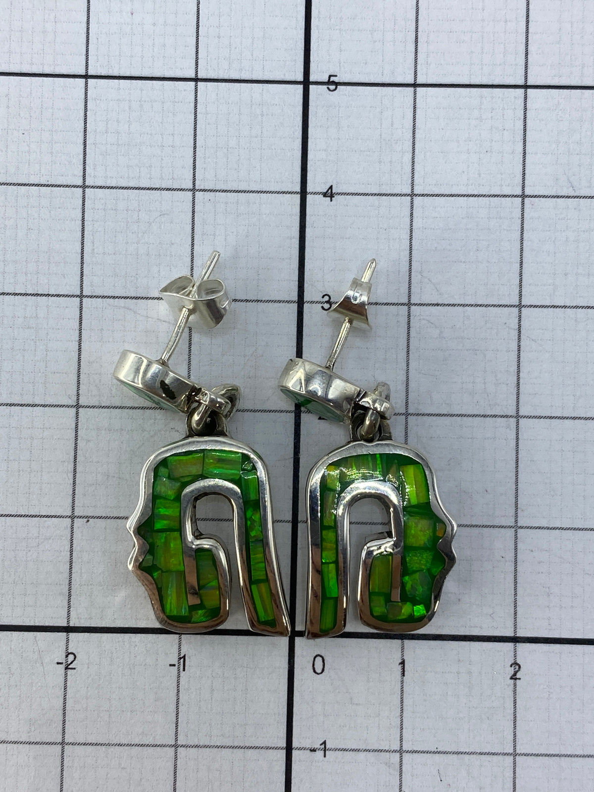 Aretes sobre fondo gris mostrando el Quinto de ley 950 grabado