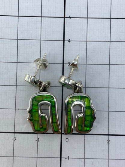 Aretes sobre fondo gris mostrando el Quinto de ley 950 grabado