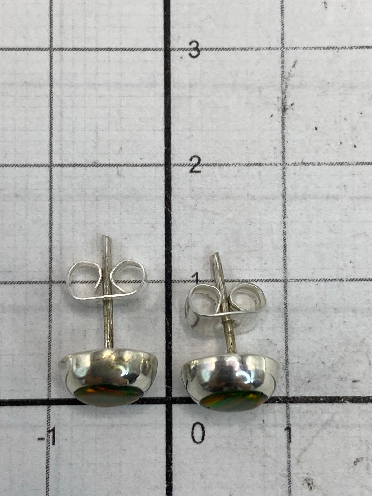 Aretes de ópalo fuego de Taxco sobre fondo blanco mostrando el Quinto 925