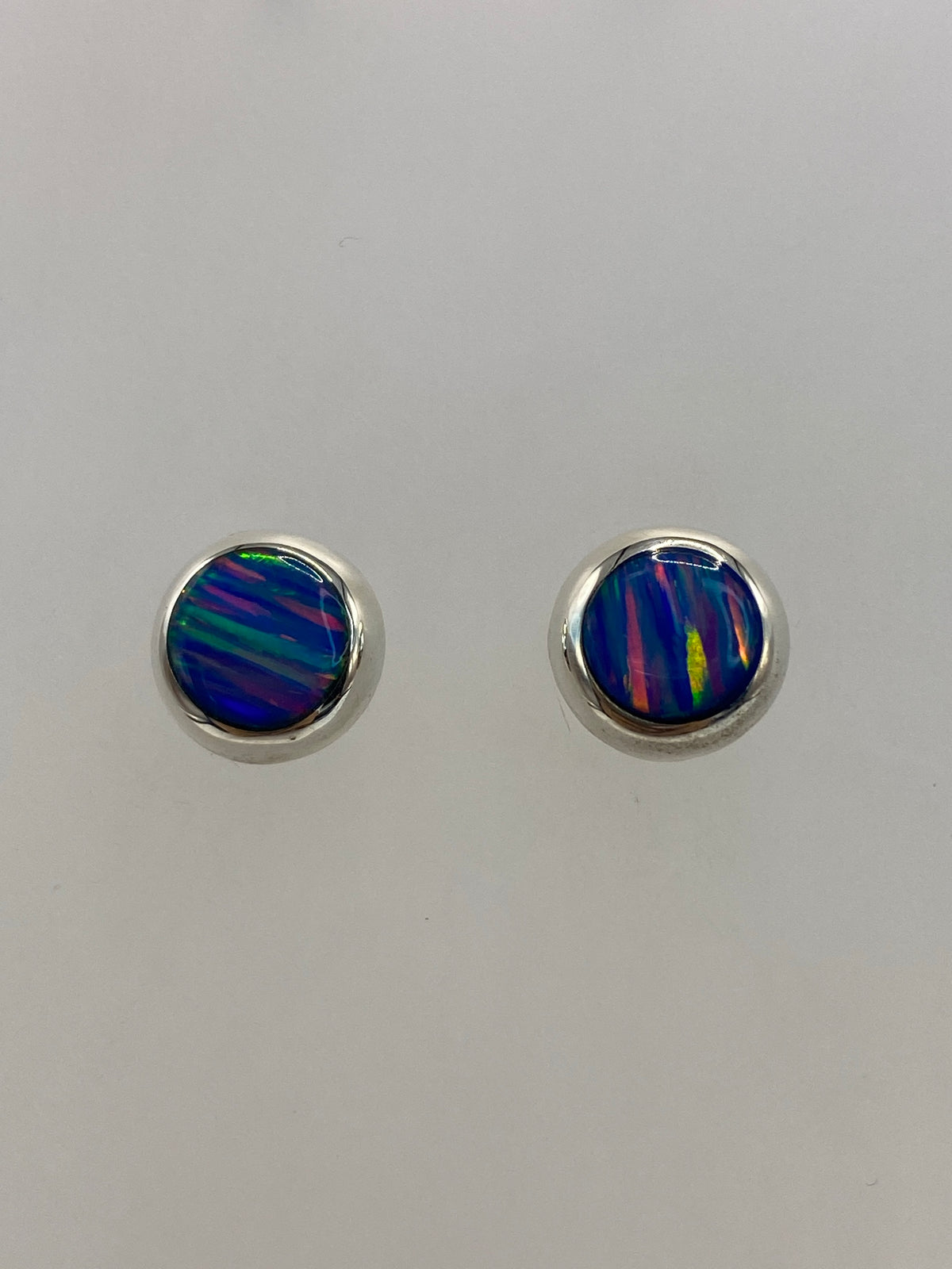 Arete individual de plata 925 con ópalo de fuego engastado a mano, vista frontal de la piedra multicolor