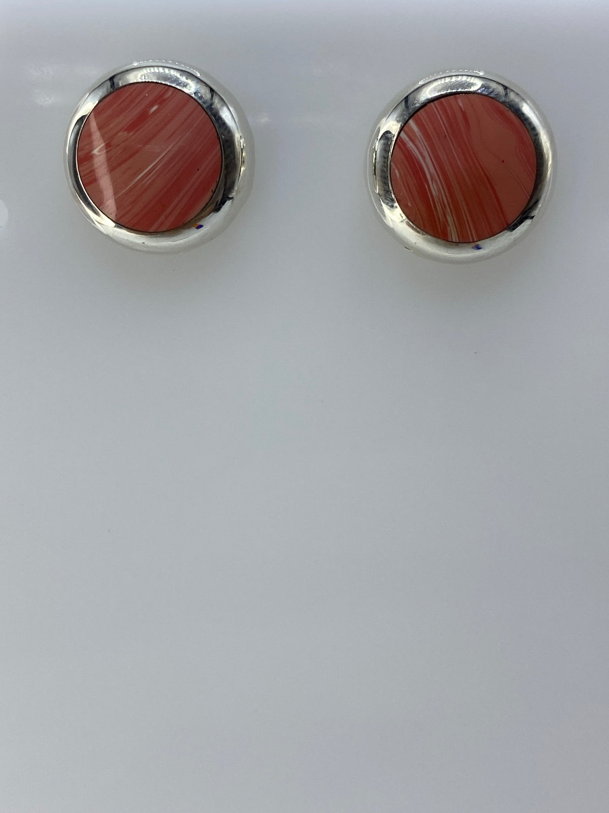 Par de aretes de plata con piedra rosa redonda engastada, vista frontal