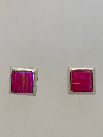 Aretes de plata 925 sobre fondo azul, mostrando el brillo mineral del ópalo