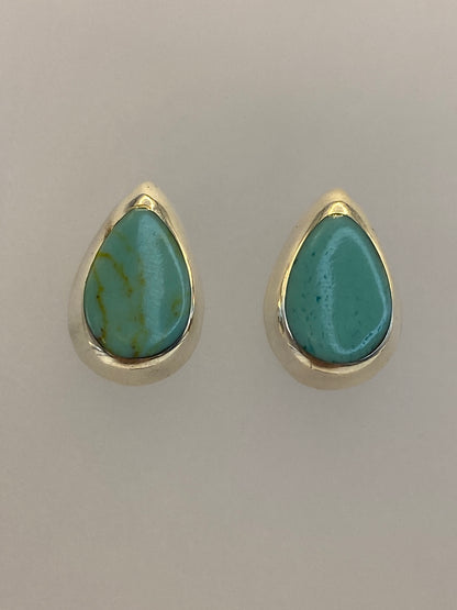 Par de aretes turquesa sobre regla mostrando tamaño de 1.4 cm