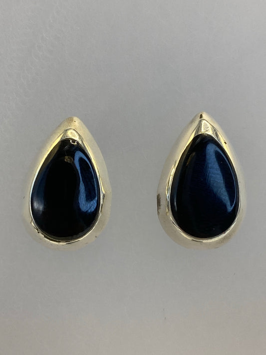 Par de aretes de plata con onix negro pulido, vista frontal mostrando el tamaño compacto