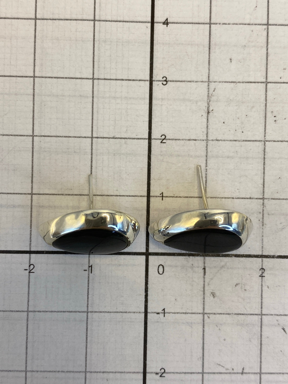 Aretes con onix negro mostrando el Quinto 925 grabado en la plata