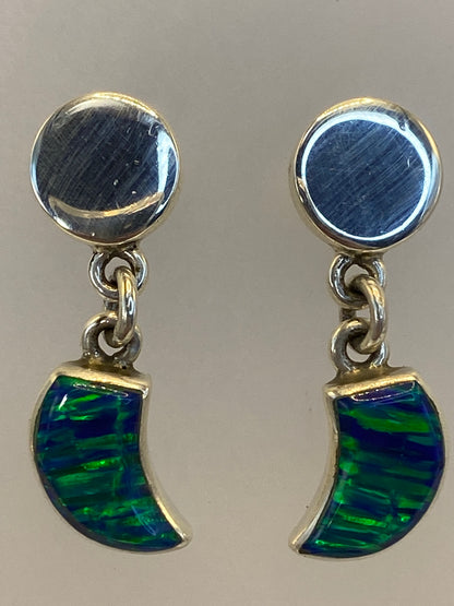 Aretes sobre fondo blanco mostrando el brillo del ópalo en tono verde
