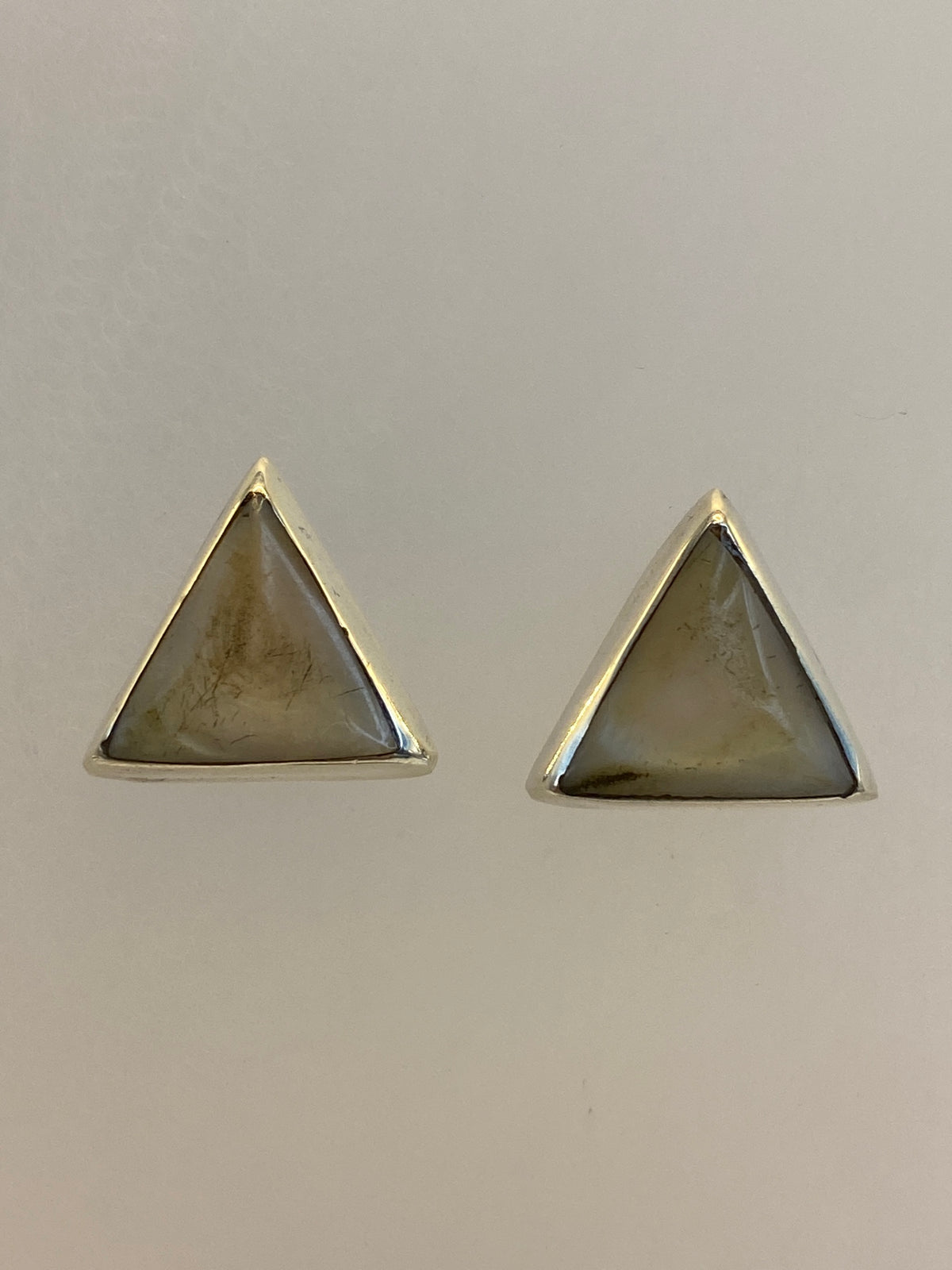 Detalle frontal de los aretes mostrando la piedra y el engaste a mano