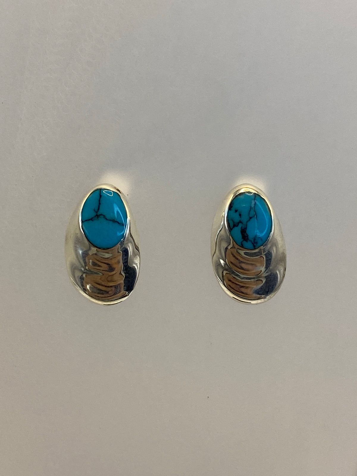 Detalle del engaste a mano de la turquesa en plata, mostrando la veta ocre y azul