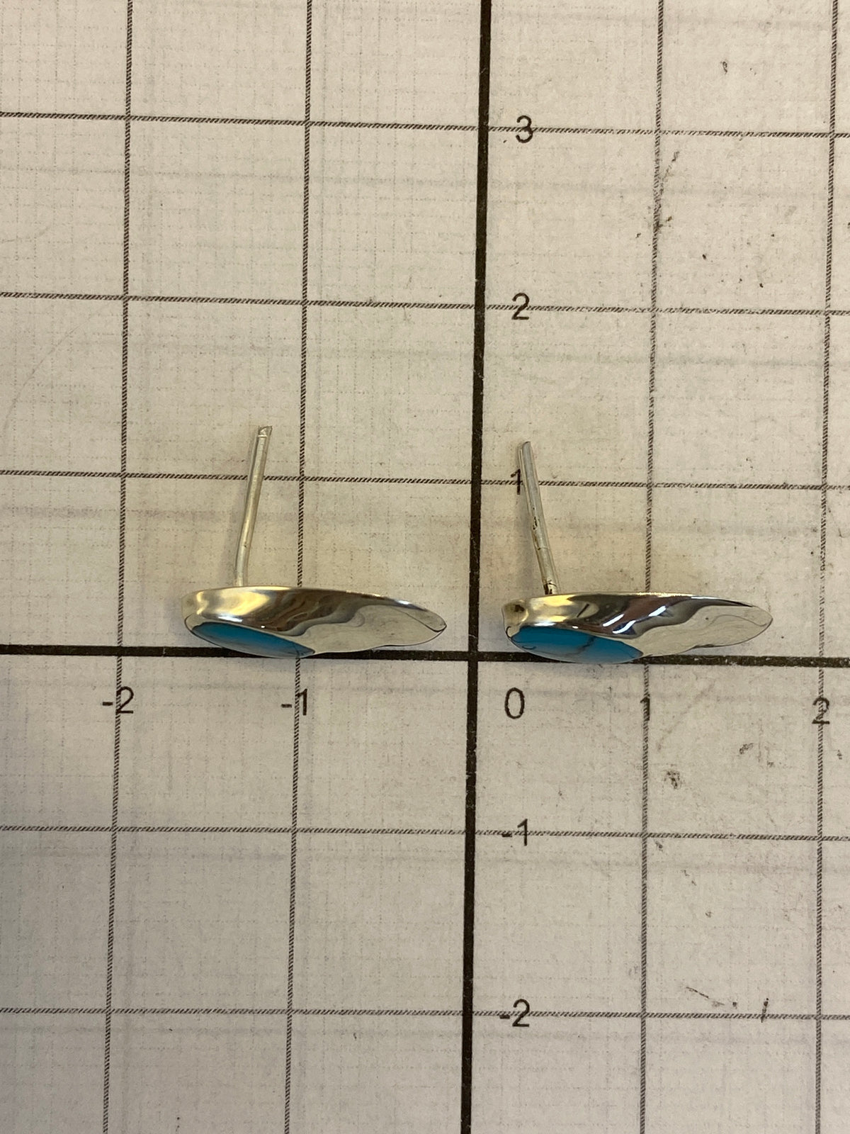 Reverso de los aretes mostrando el poste y mariposa de plata, con Quinto 925